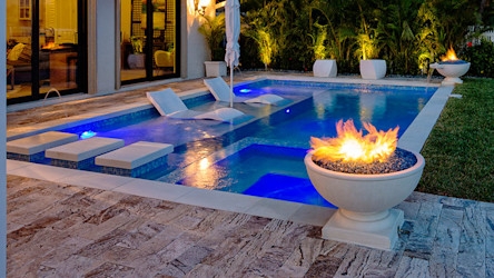 Contemporary Pool with Blue Lighting and In-Pool Loungers