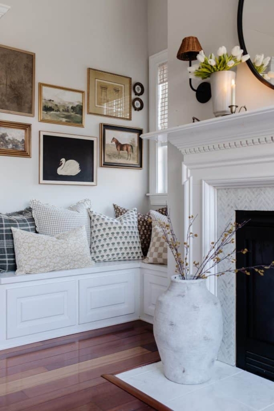 Cozy Fireplace Nook Seating Featuring Built-In Bench With Pillows And Gallery Wall