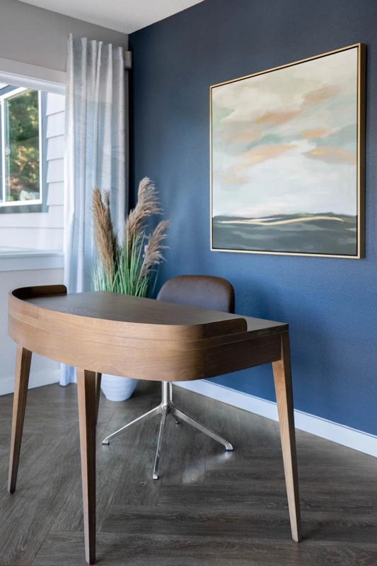Curved Writing Desk with Navy Blue Accent Wall and Herringbone Floor