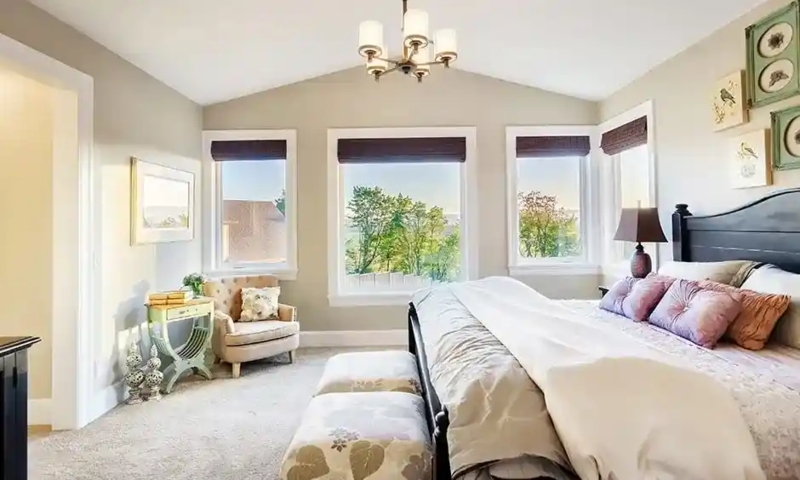 Dark Wood Bed with Triple Window Backdrop & Sloped Ceiling