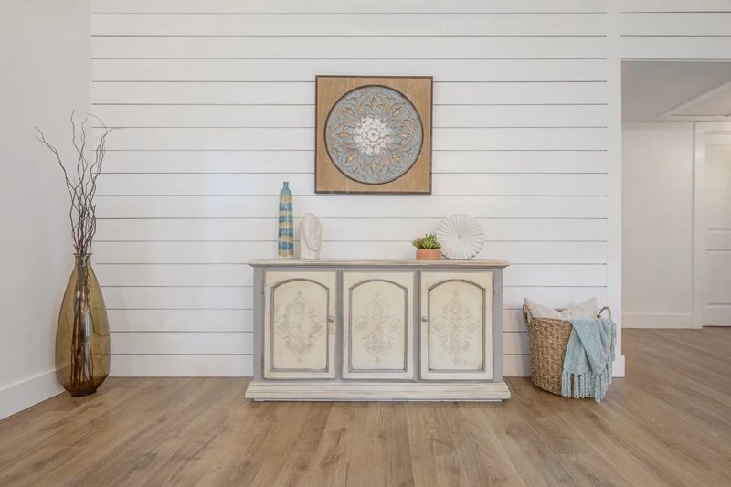 Distressed Sideboard with Carved Panels against Shiplap Accent Wall
