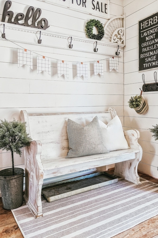Distressed White Wood Pew-Style Bench in a Farmhouse Entryway