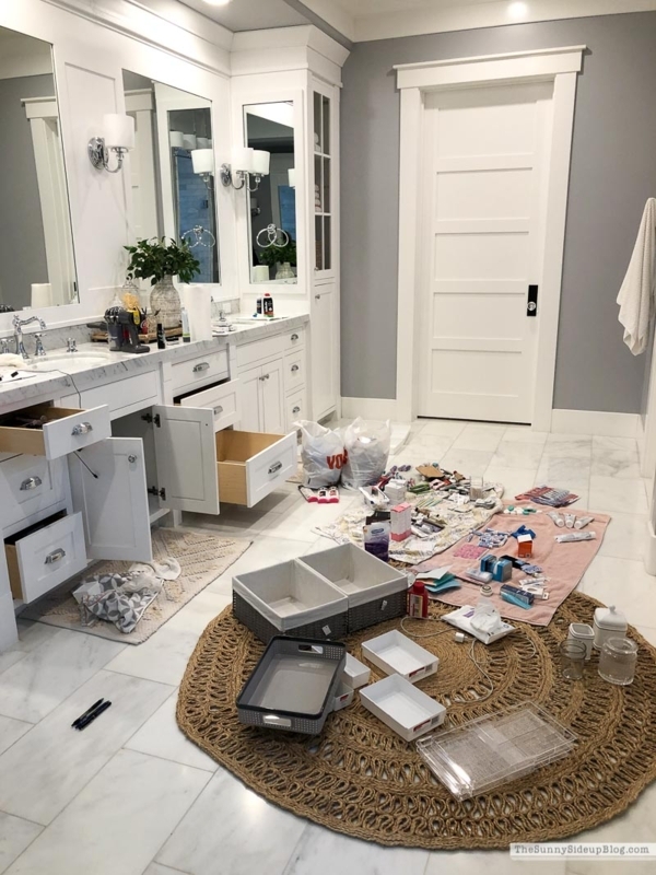 Double Vanity bathroom with round jute rug and shaker cabinetry. SEO: storage bins for toiletries.