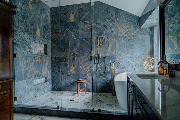 Dramatic Marble Walls in Bathroom with Gold Fixtures