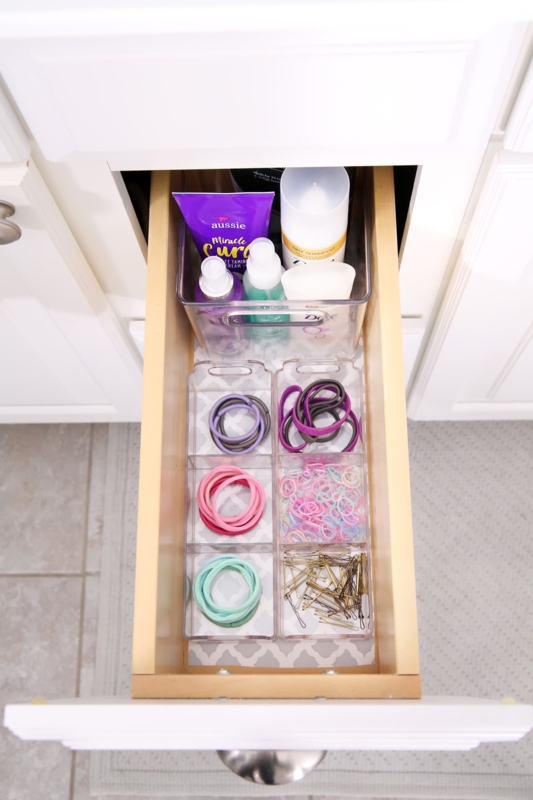 Drawer Organizer with patterned drawer liner. SEO: organized hair tie bins in vanity.