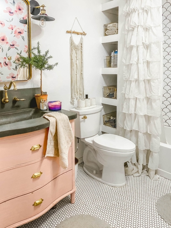 Eclectic Bathroom with curved pink vanity and recessed wall niches. SEO: floral wallpaper decor.