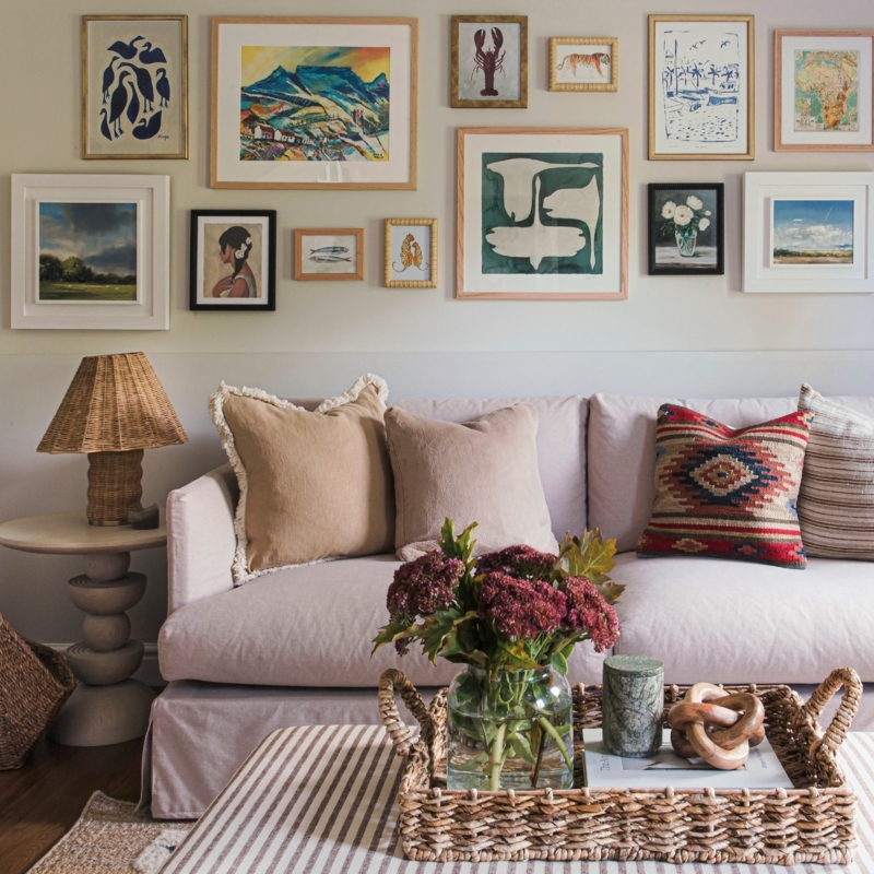 Eclectic Gallery Wall Layout With Woven Rattan Table Lamp And Striped Ottoman