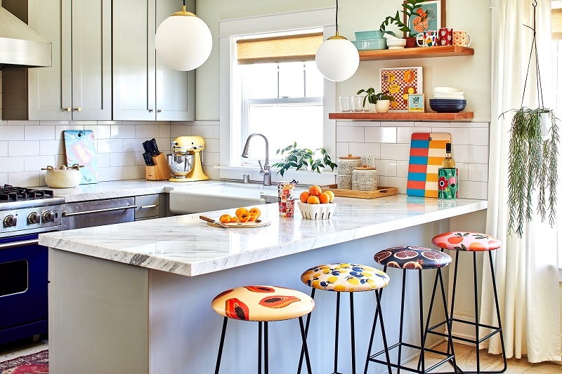 Eclectic Kitchen with Patterned Fruit Bar Stools and Globe Pendants