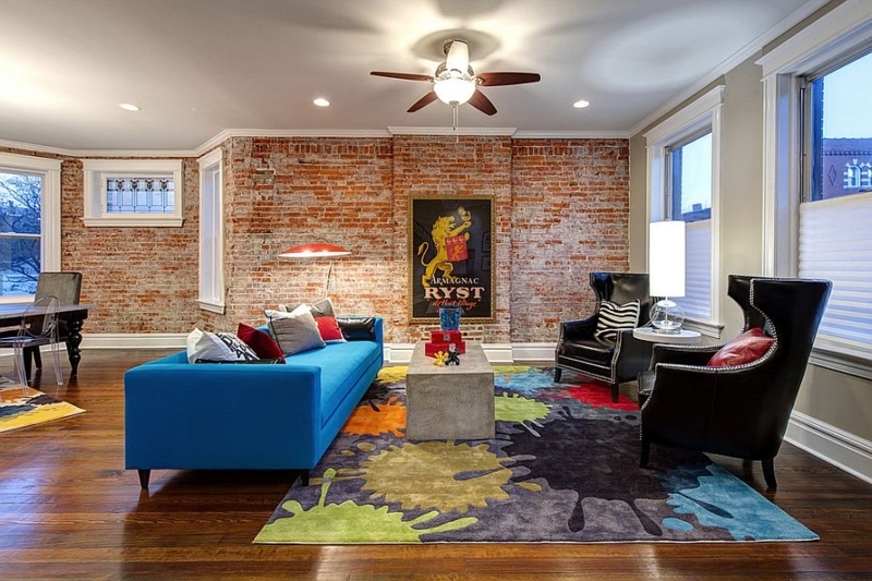 Eclectic Living Room: Exposed Brick, Vibrant Blue Sofa & Splatter Rug
