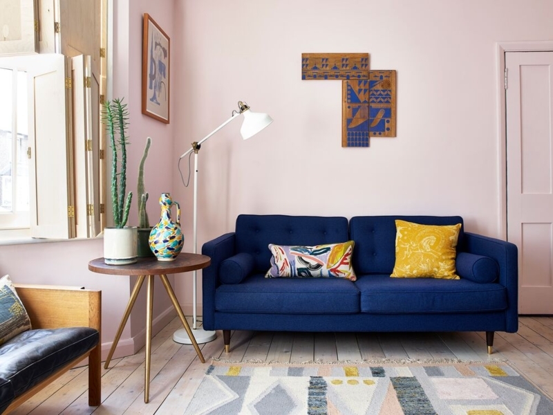 Eclectic Navy Blue Sofa Pink Walls Bolster Pillows Tapered Legs