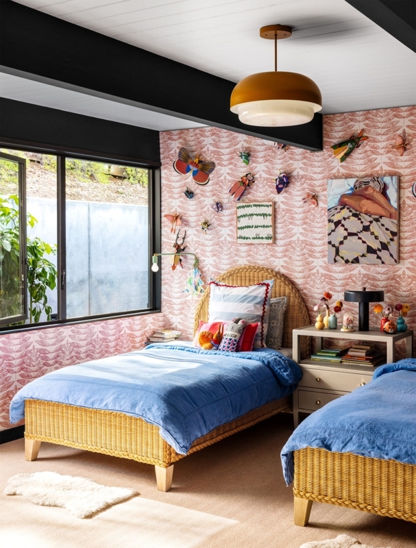 Eclectic Wicker Twin Beds with Pink Patterned Wallpaper and Wall Art
