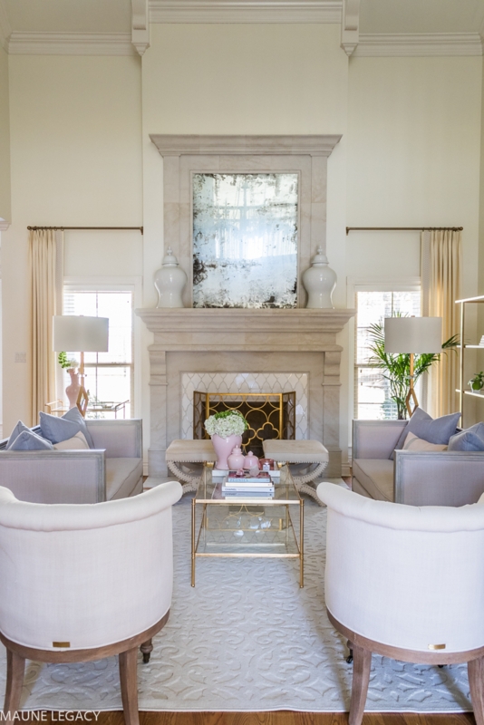 Elegant Living Room with White Barrel Chairs and Antiqued Mirror Feature