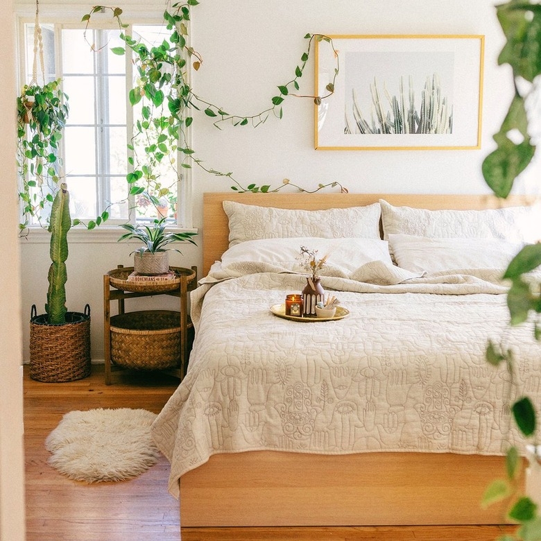 Embroidered Hamsa Quilt and Trailing Plants in a Bohemian Bedroom