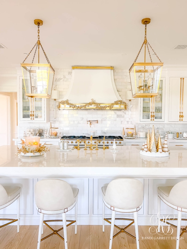 Festive White and Gold Kitchen with Lantern Pendants and Marble Backsplash