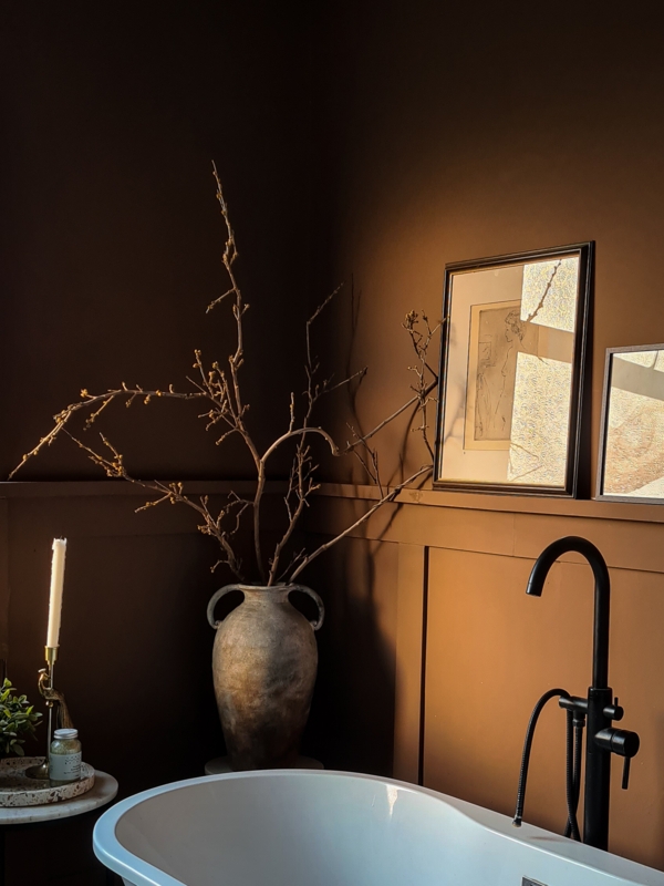 Freestanding Bathtub against Chocolate Brown Walls and Black Faucet