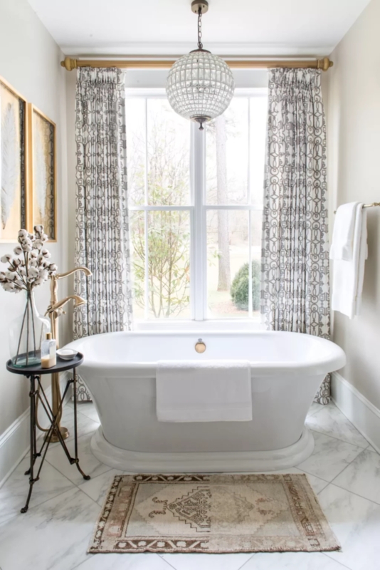 Freestanding Bathtub with Gold Faucet and Geometric Curtains