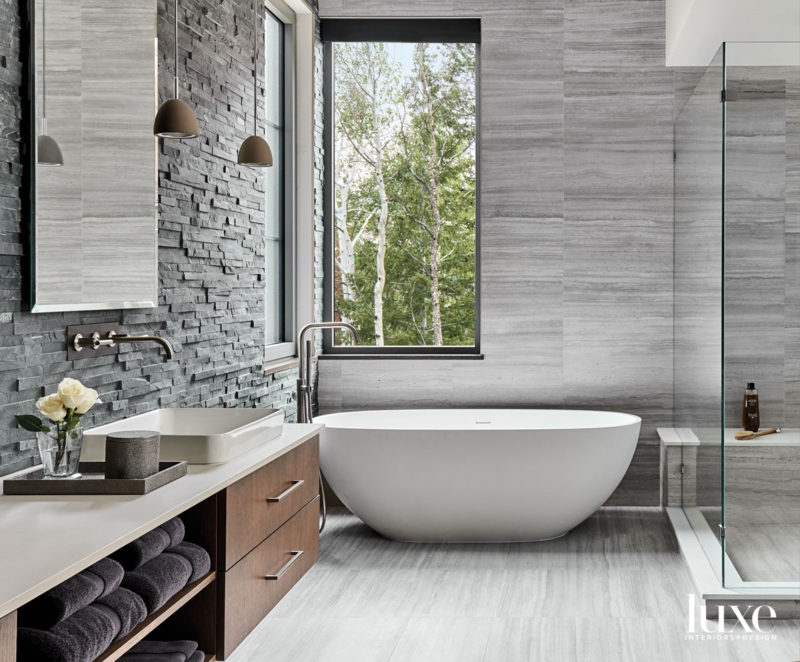 Freestanding Tub by Window with Stacked Stone Accent Wall