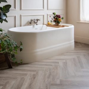 Freestanding Tub With Wall Paneling And LVT Herringbone Flooring Design