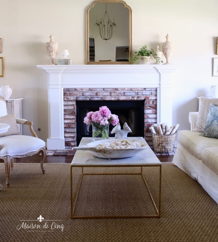 French Country Lounge with Whitewashed Brick Fireplace and Gold Mirror