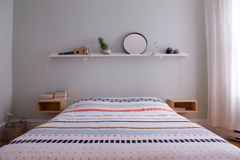 Full-Width Floating Shelf and Nightstands Against Sage Green Wall
