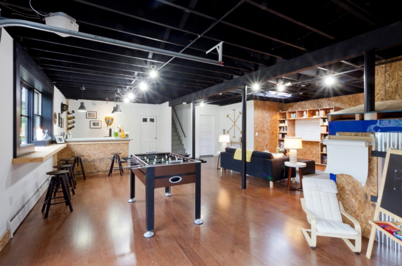 Game Room with Black Exposed Ceiling and Raw OSB Wall Paneling Design