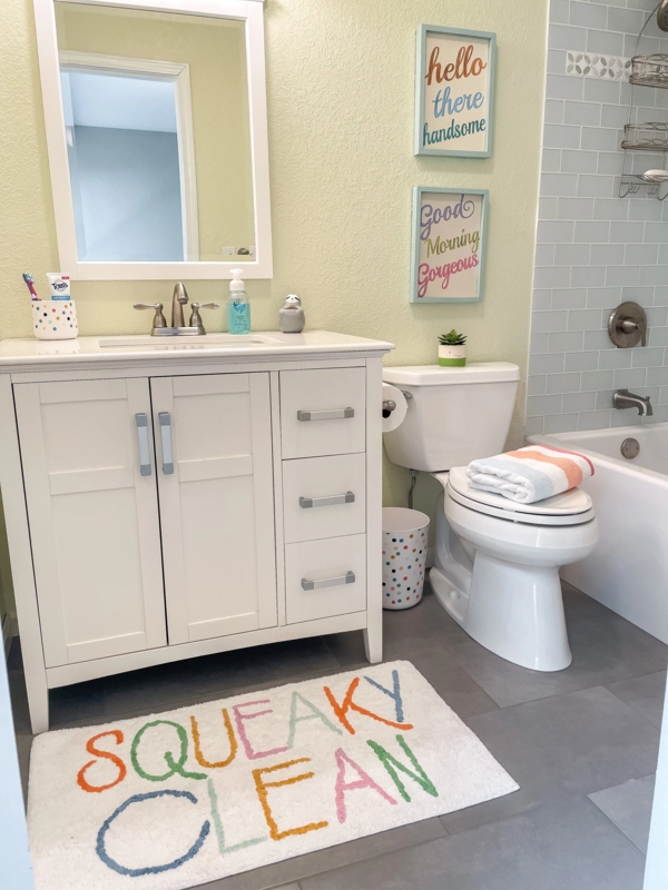Gender Neutral Bathroom with Light Green Walls and Typography Bath Rug