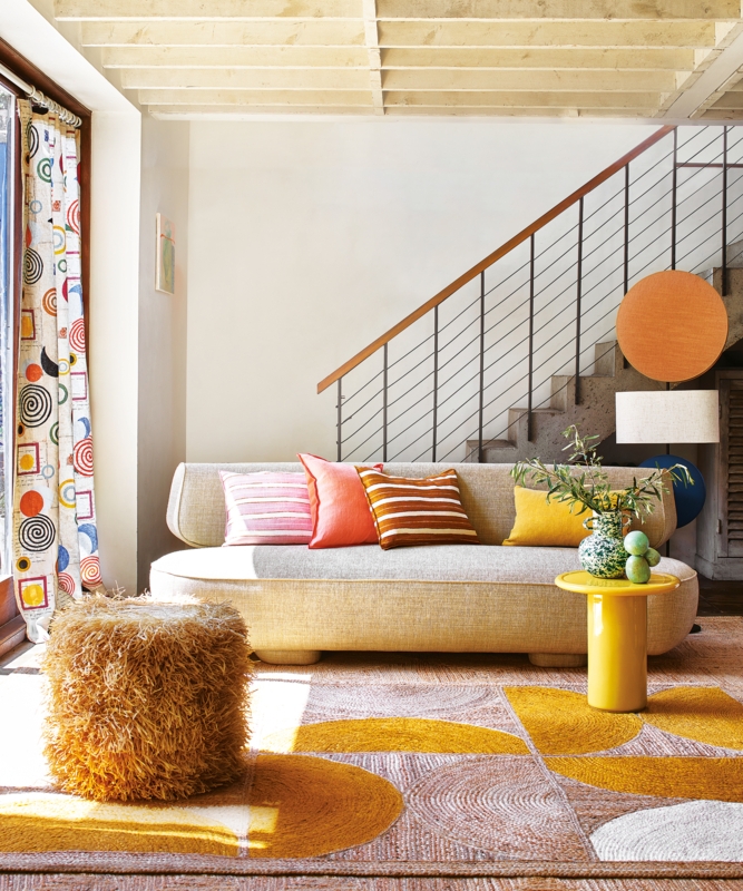 Geometric Area Rug in a Bright Yellow and Orange Living Room.