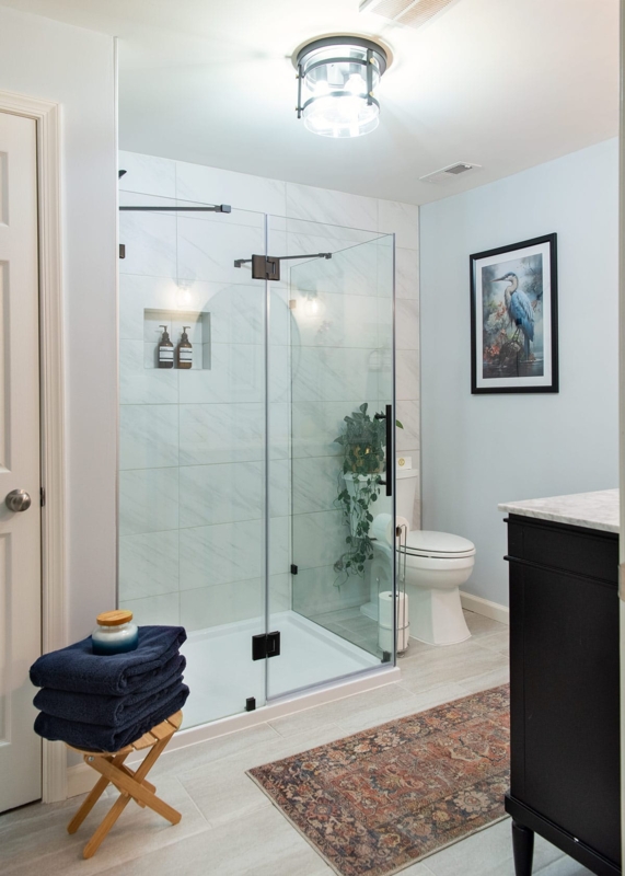 Glass Walk In Shower Design in Pale Blue Bathroom with Black Hardware