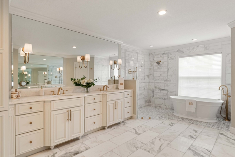 Gold on White Bathroom with Marble Tile Surround and Freestanding Tub