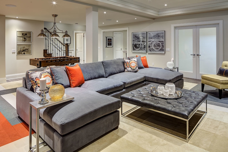 Gray Sectional Sofa with Orange Accents and Tufted Ottoman Table