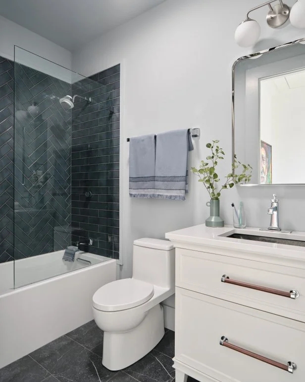 Guest Bathroom featuring Charcoal Herringbone Tile and Wood Accents