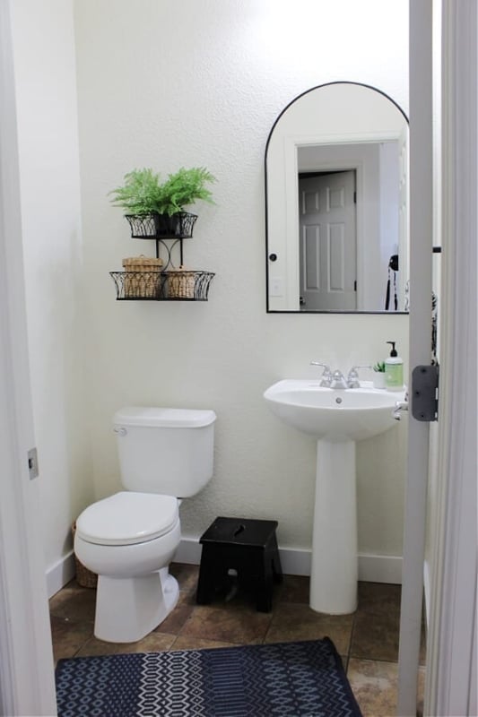 Half Bath Minimalist White Decor: Arched Mirror and Wire Wall Basket
