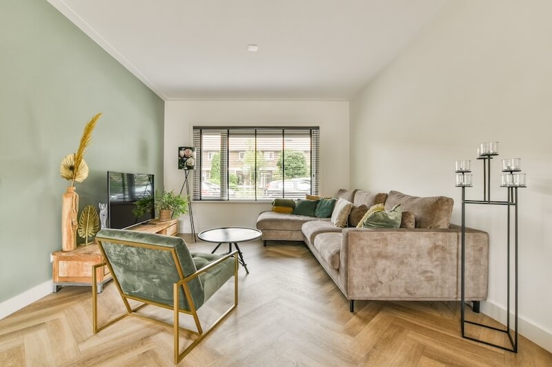 Herringbone Wood Floors in Sage Green Living Room with Gold Chair