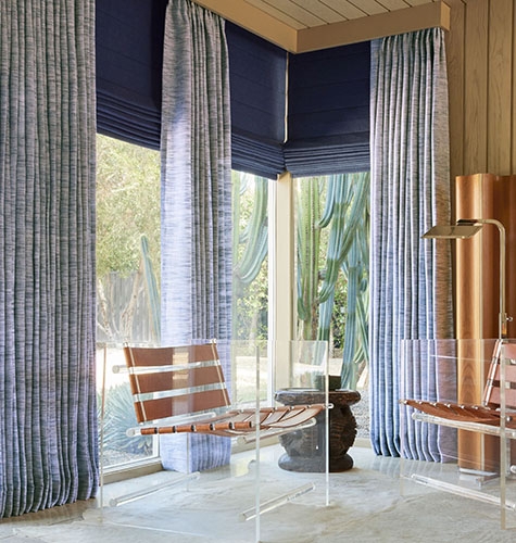 Layered Indigo Window Treatments and Acrylic Chairs