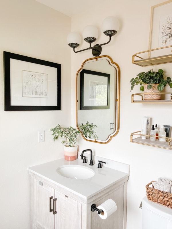 Light Wood Bathroom Vanity with Arched Gold Mirror and Black Faucet