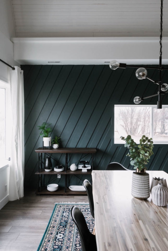 Light Wood Dining Table against Dark Teal Diagonal Slat Accent Wall