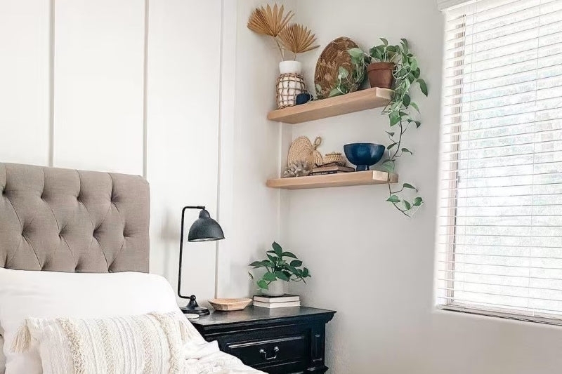 Light Wood Floating Shelves above Tufted Headboard in Boho Bedroom