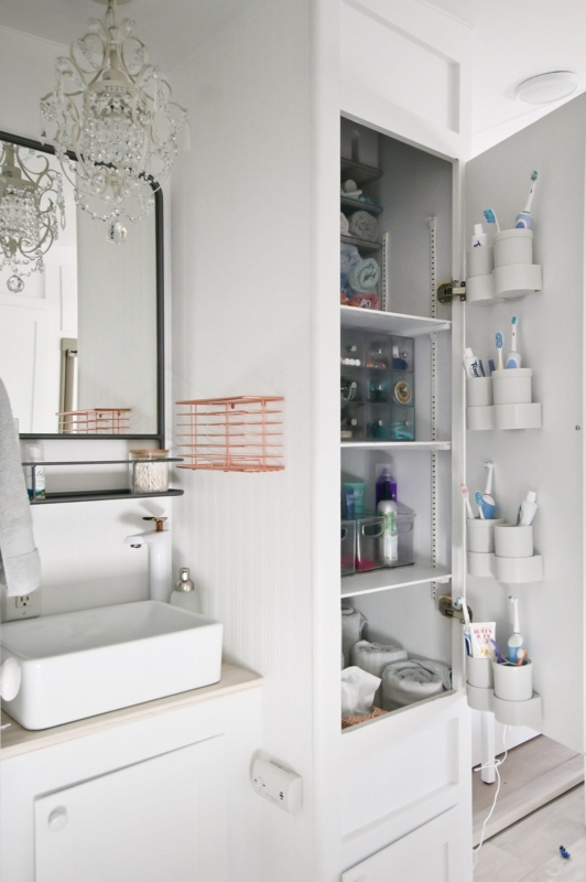 Linen Tower with crystal chandelier accent and door storage. SEO: narrow bathroom organization.