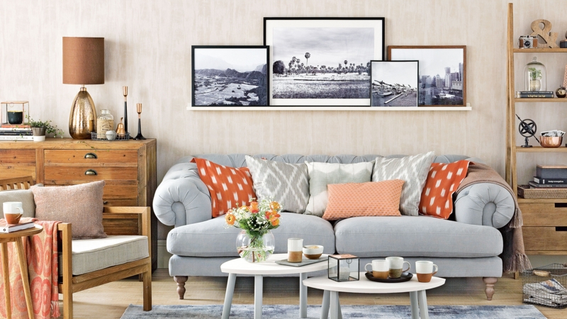 Living Room Picture Ledge Gallery With Burnt Orange Accents And Tufted Sofa