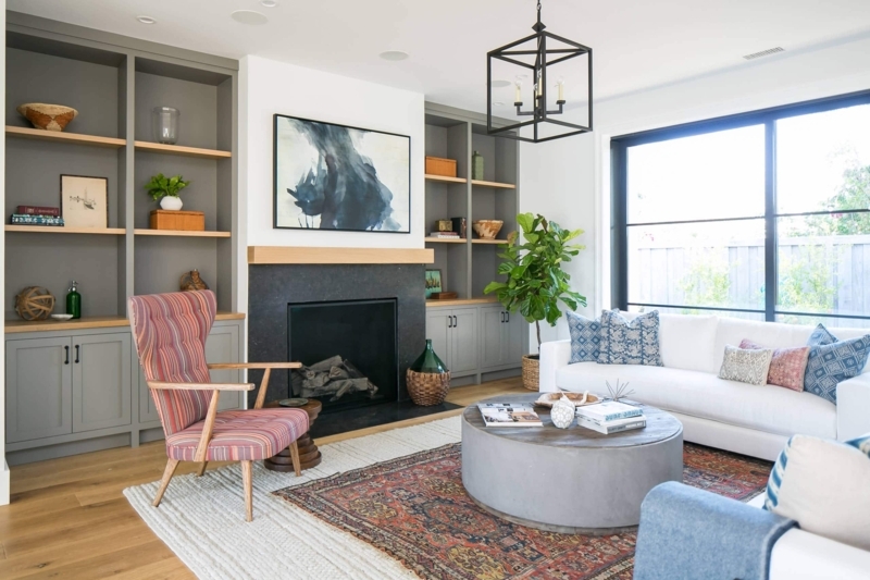 Living Room Rug Layering Ideas with Gray Built-in Fireplace Shelving.
