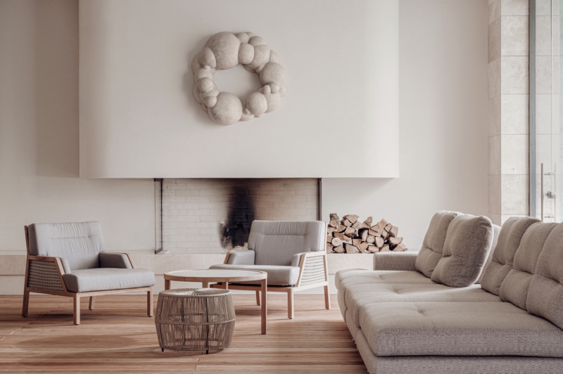 Living Room: Sculptural Wall Art Fireplace Decor with Cane Panel Chairs.