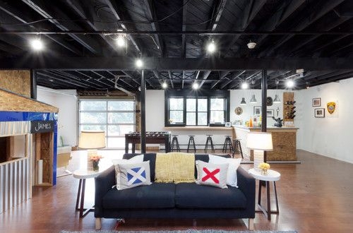 Lounge with Nautical Accent Pillow Styling and Black Exposed Ceiling