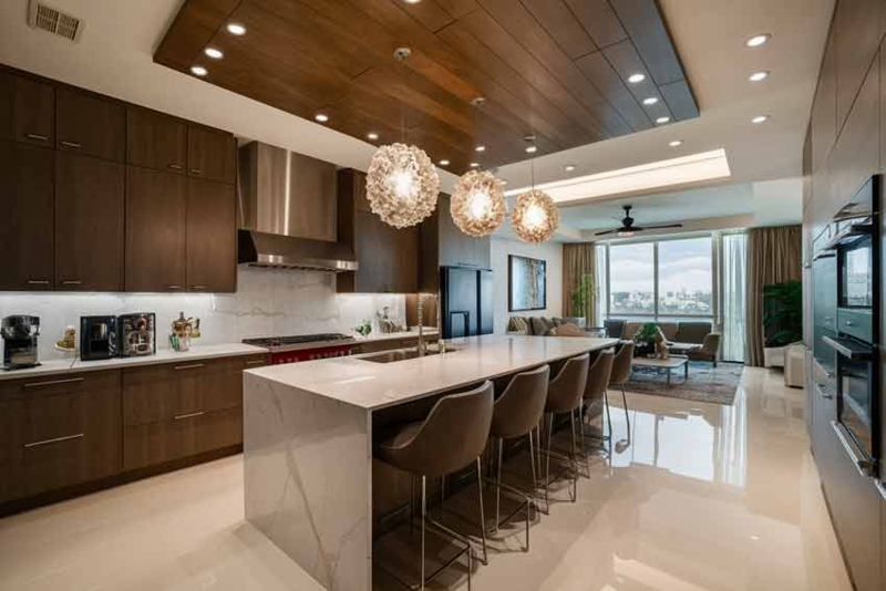 Luxury Kitchen with Wood Paneled Ceiling and Marble Waterfall Island