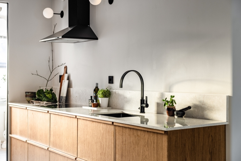 Matte Black Faucet with Wood Cabinets and Stone Backsplash