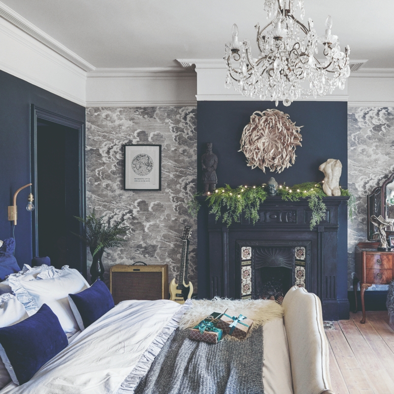 Maximalist Bedroom Decor with Cloud Wallpaper and Black Fireplace Mantel