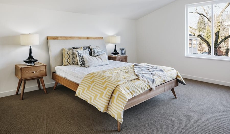 Mid-Century Modern Bedroom with Yellow Geometric Bedding and Brown Carpet