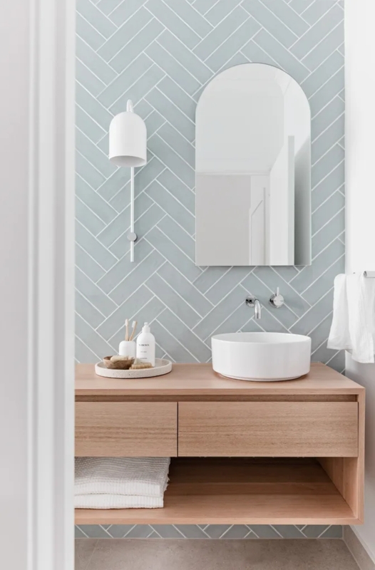 Minimalist Floating Vanity with Pale Blue Herringbone Tile Backsplash