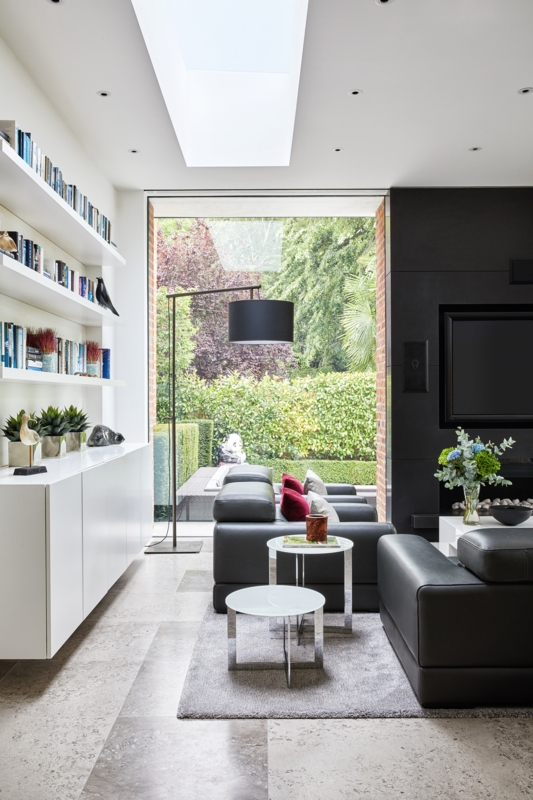 Minimalist Grey Stone Tile Living Room: Black Feature Wall & Skylight