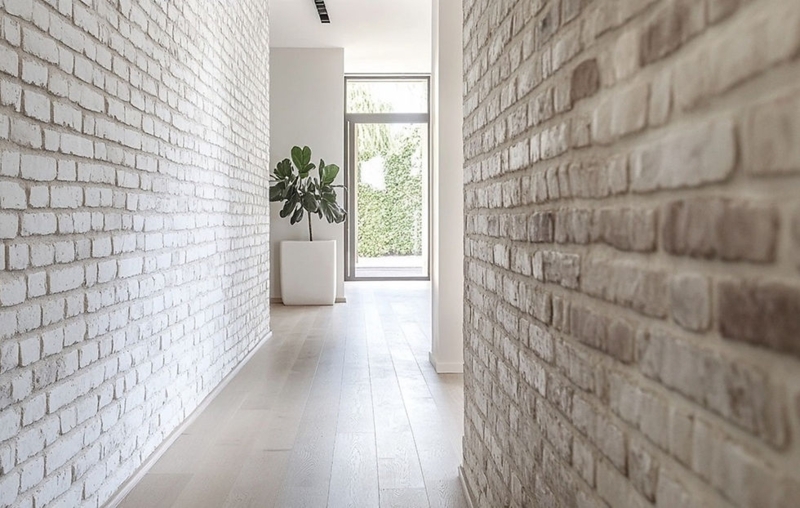 Minimalist Hallway: Whitewashed Brick Walls & Light Oak Floors