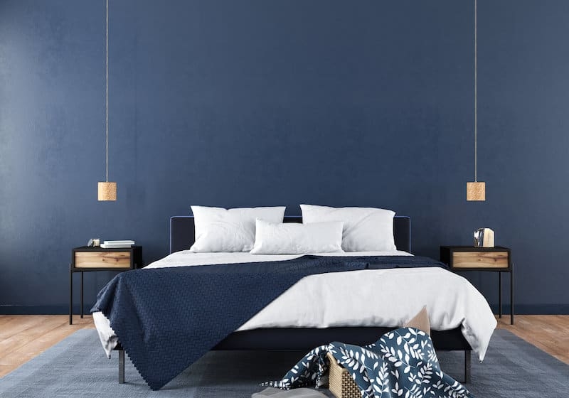 Minimalist Low Profile Bed with Cylindrical Pendants and Quilted Throw